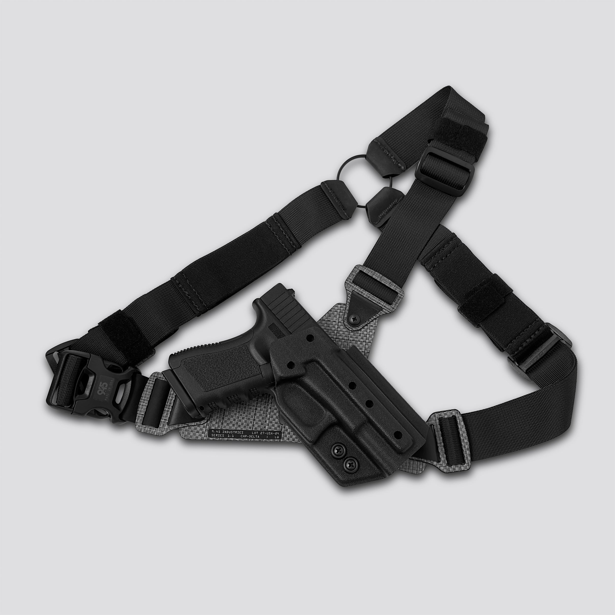 Black gun holster with shoulder strap on a light gray background