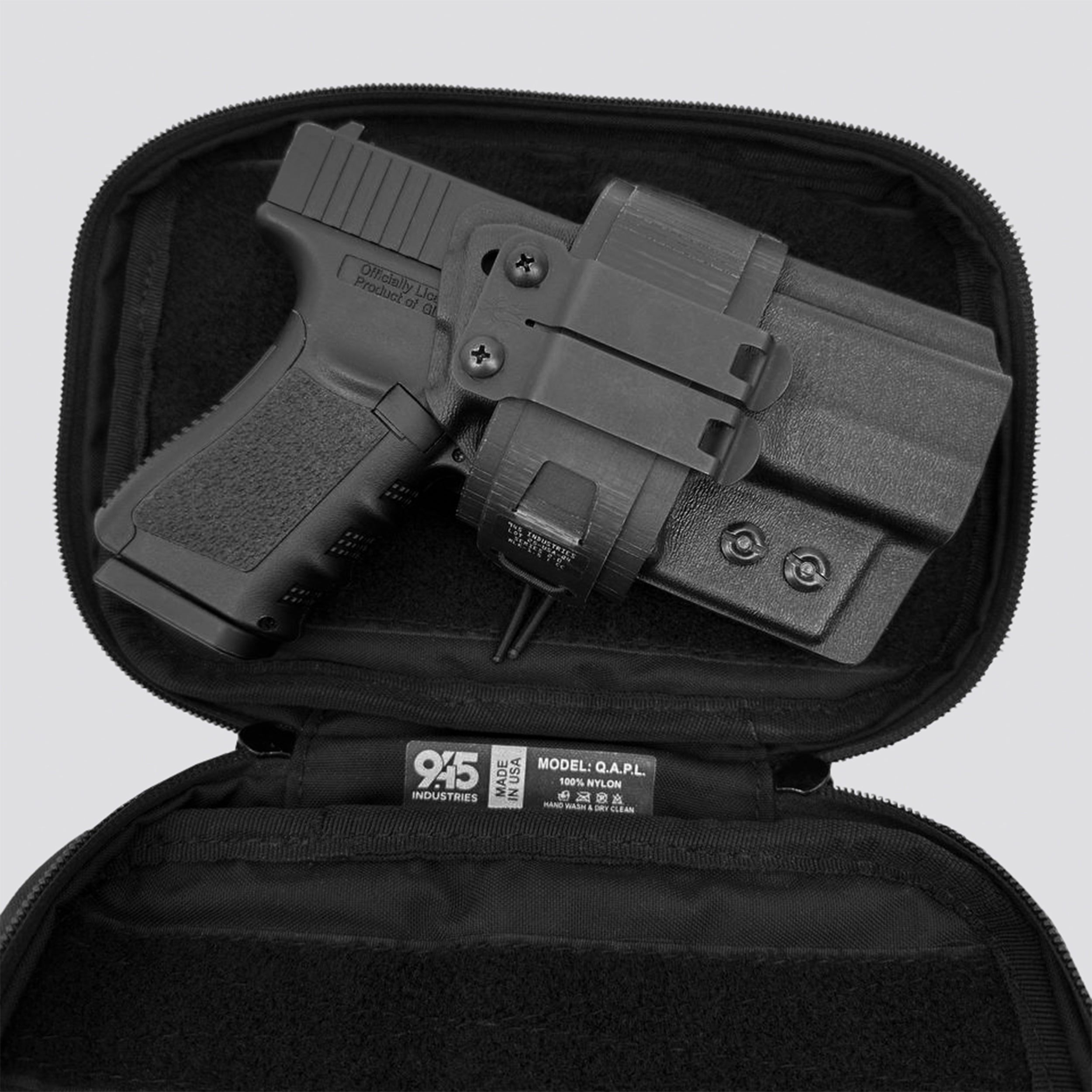 Black on titanium IWB Tegris holster adapter with titanium panel and black belt with IWB holster and black QAPL bag on a light gray background