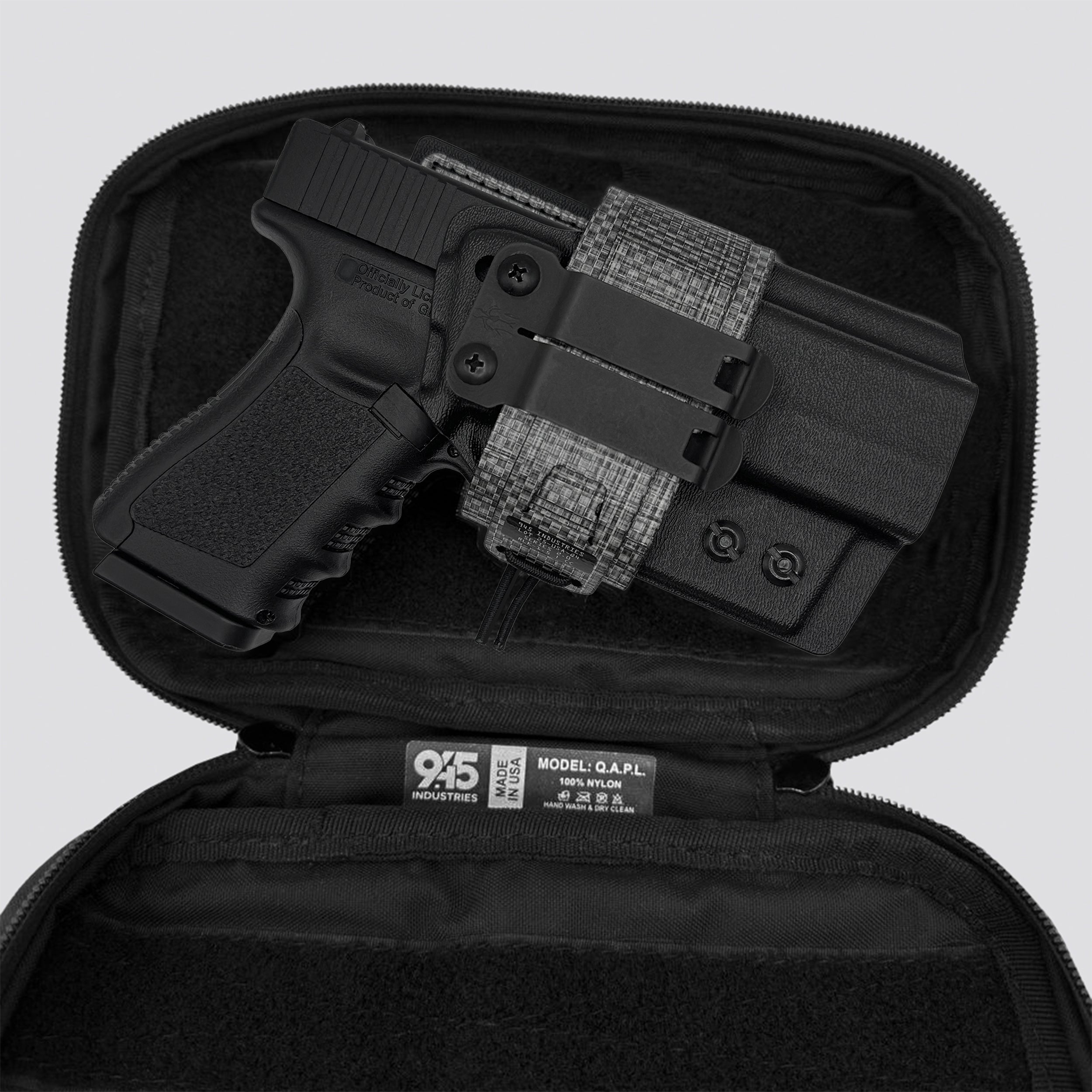 Titanium IWB Tegris holster adapter with titanium panel and belt with IWB holster and black QAPL bag on a light gray background