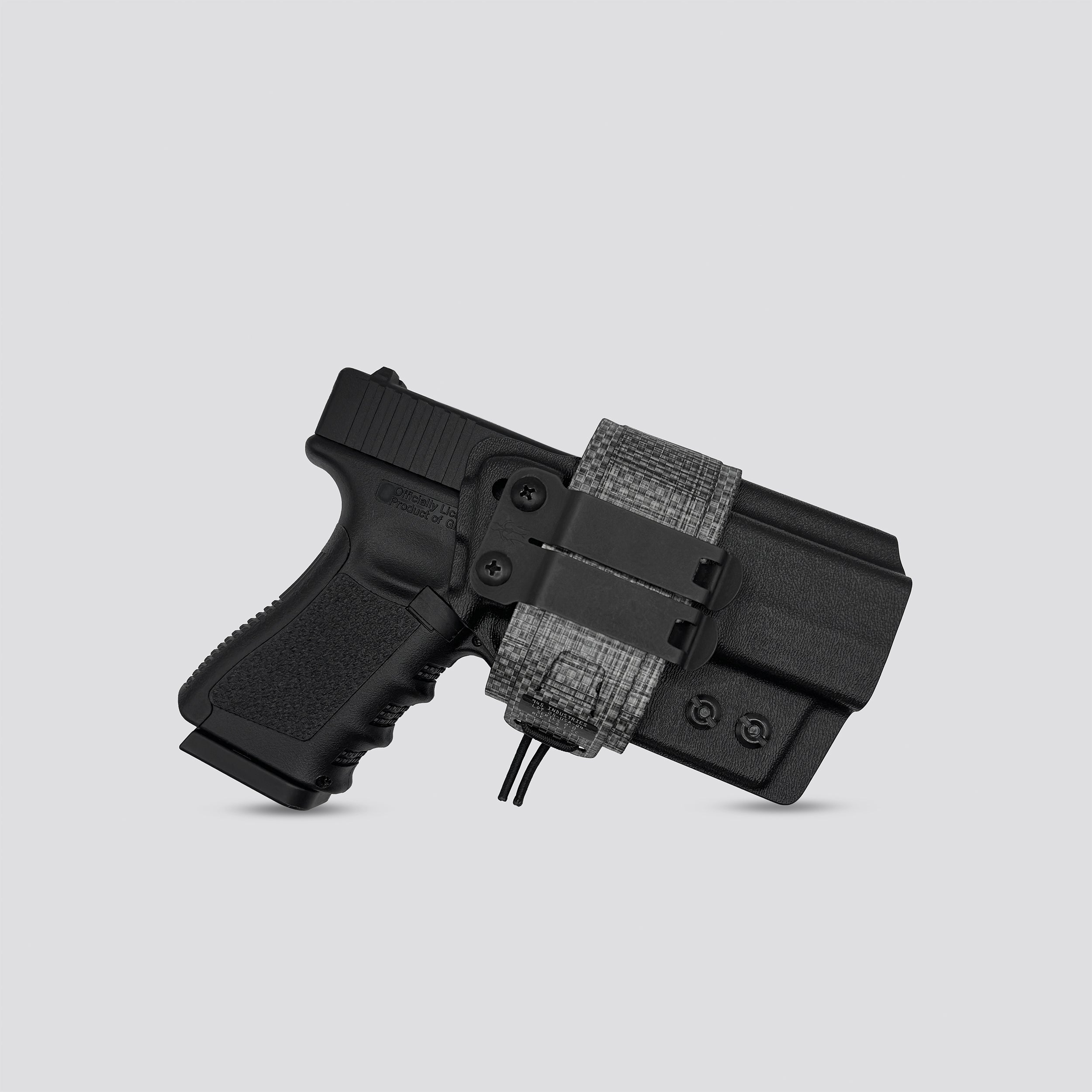 Tiitanium on black IWB tegris holster adapter with black panel and titanium belt with IWB holster on a light gray background