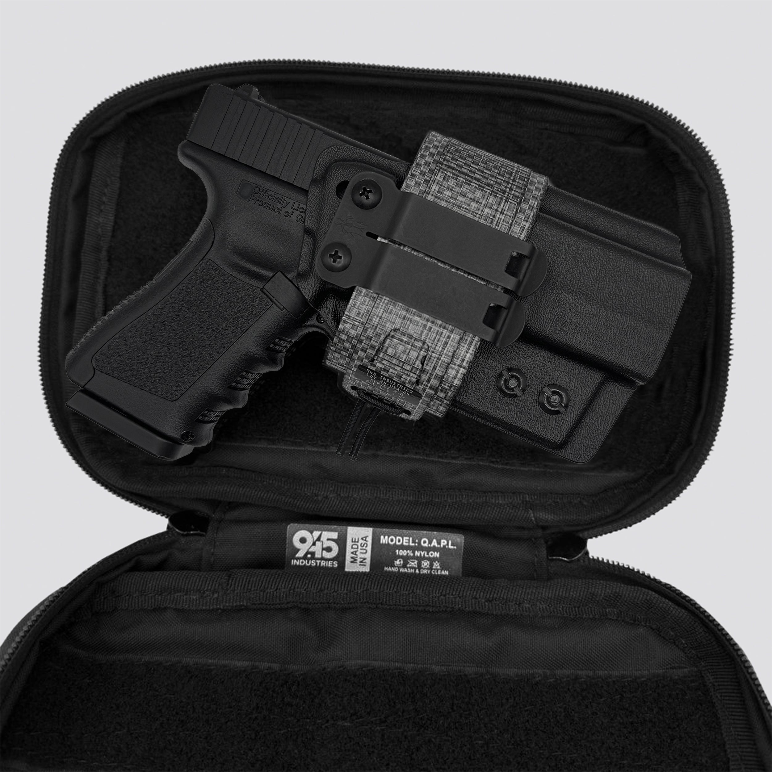 Titanium on black IWB Tegris holster adapter with black panel and titanium belt with IWB holster and black QAPL bag on a light gray background