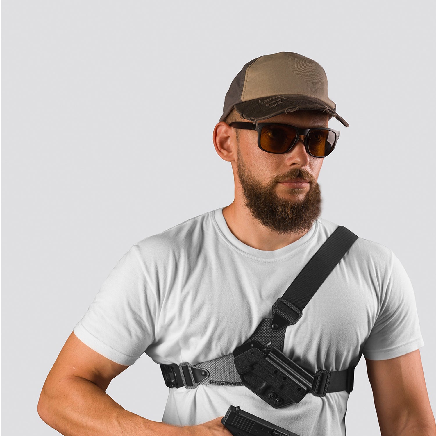 Man wearing a white t-shirt, brown cap, sunglasses, and carrying a black holster with a gun on a light gray background