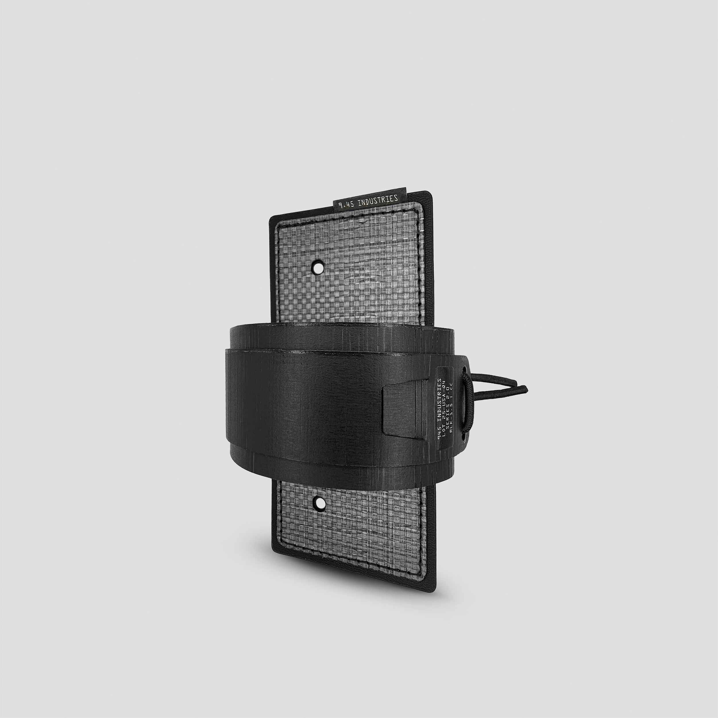 Black on titanium IWB tegris holster adapter with titanium panel and black belt on a light gray background