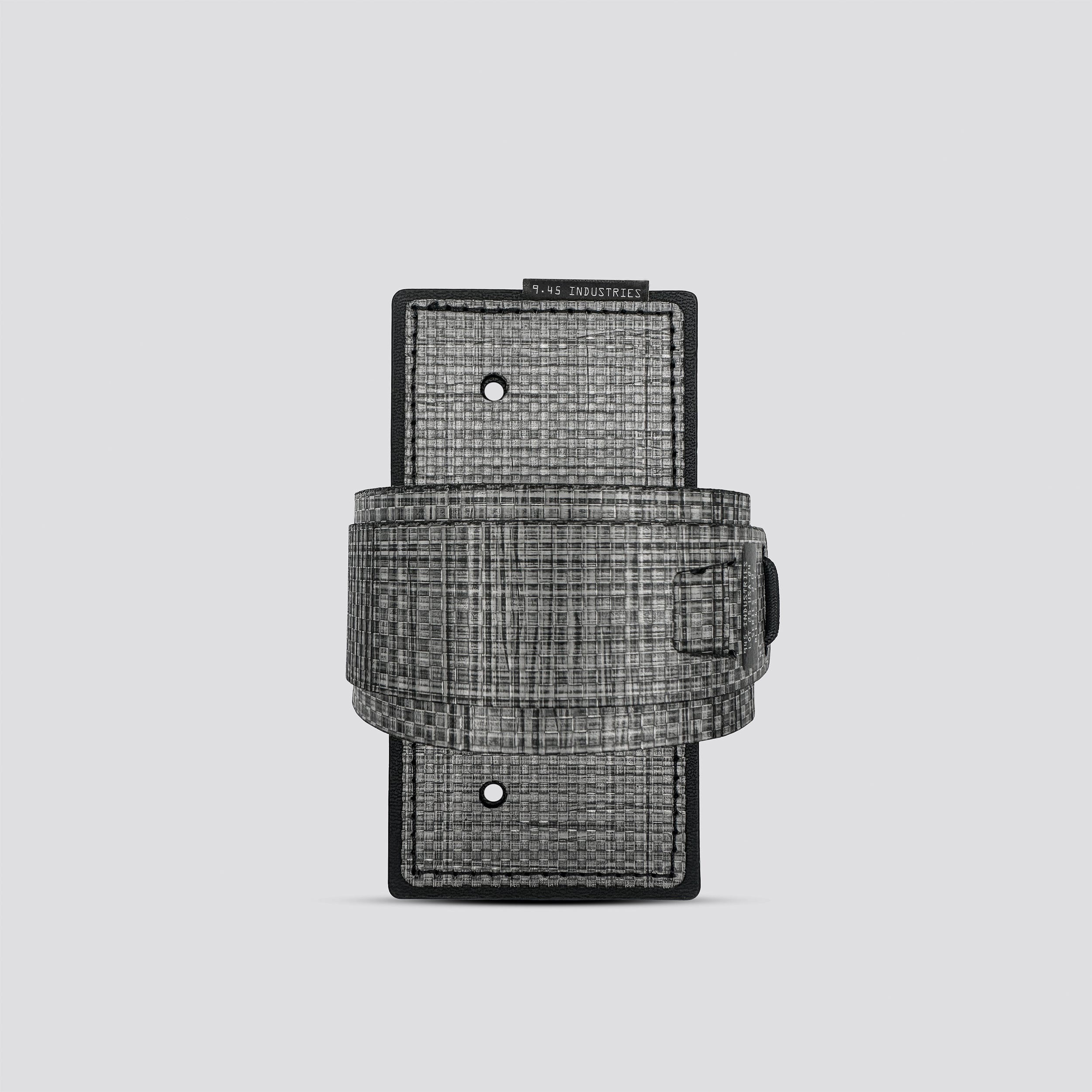 Titanium IWB tegris holster adapter with titanium panel and titanium belt on a light gray background