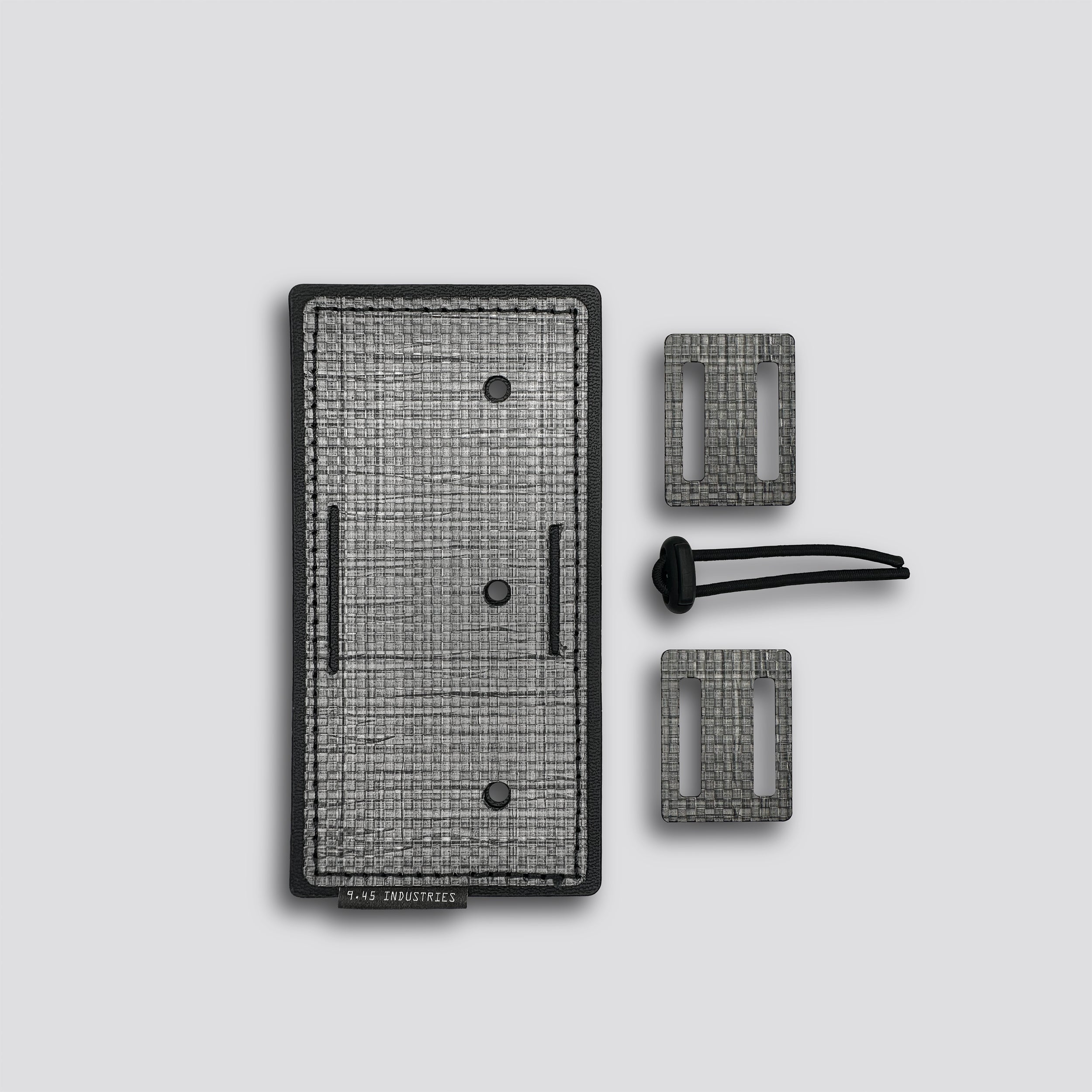 Titanium panel with two loops and a belt lock on a light gray background