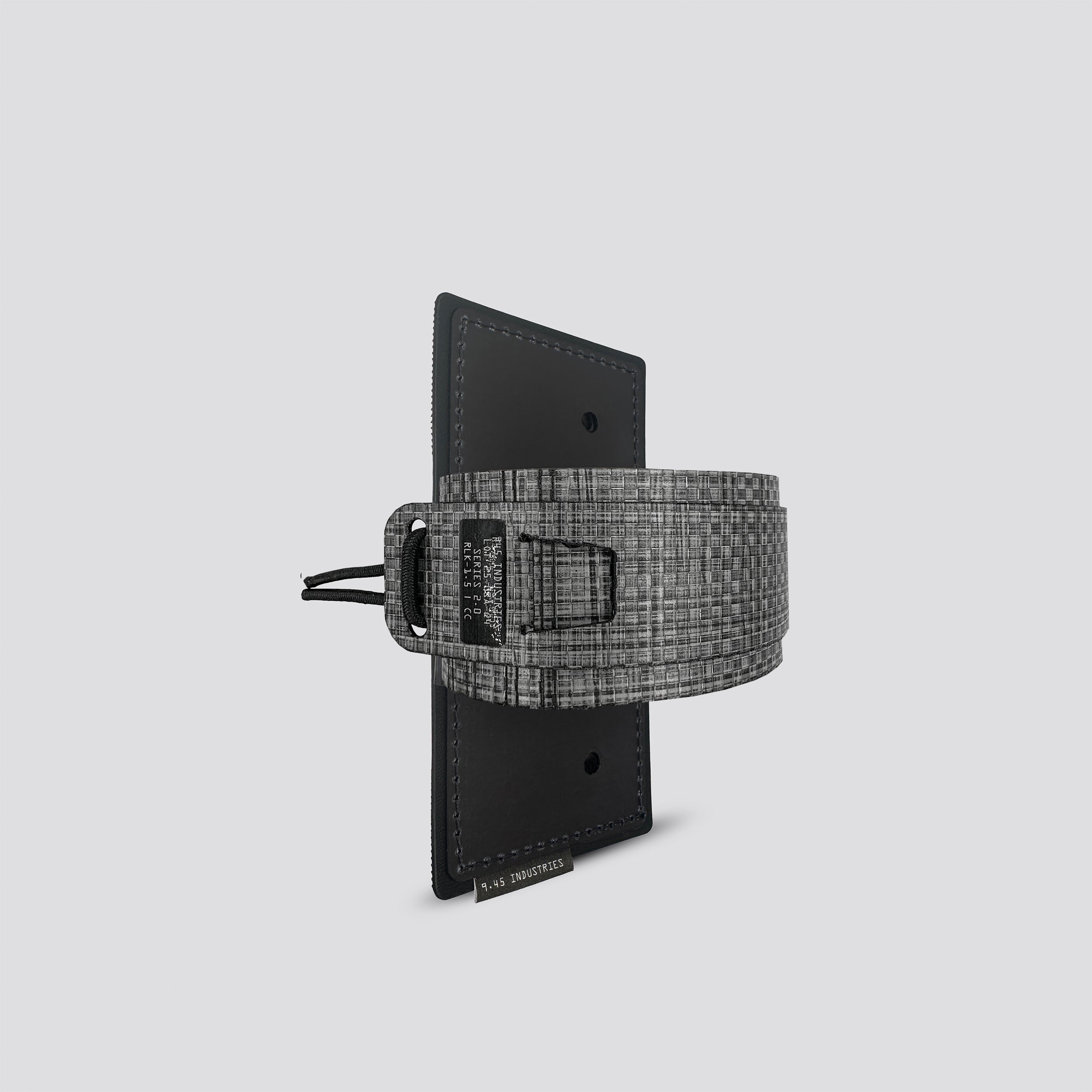 Titanium on black IWB tegris holster adapter with black panel and titanium belt on a light gray background